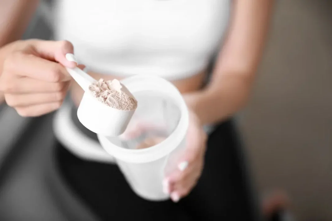 young woman holding protein powder