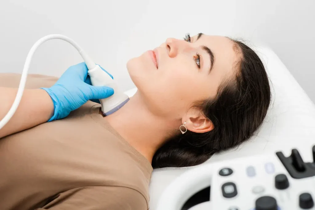 A lady having examination of her thyroid. 