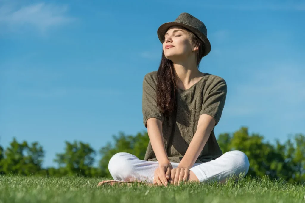 A lady is sitting on grass. 